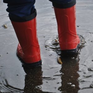 foto di due stivaletti in una cantina con acqua sul pavimento